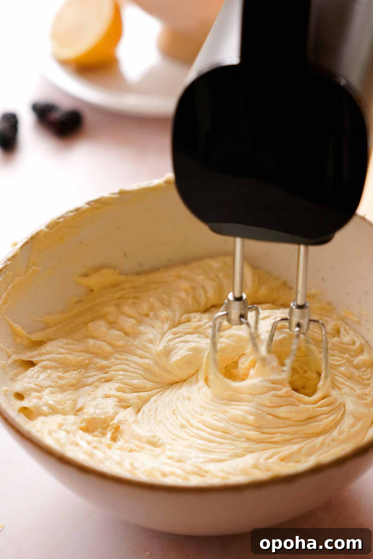 creaming lemon pound cake batter in a large bowl with electric mixer