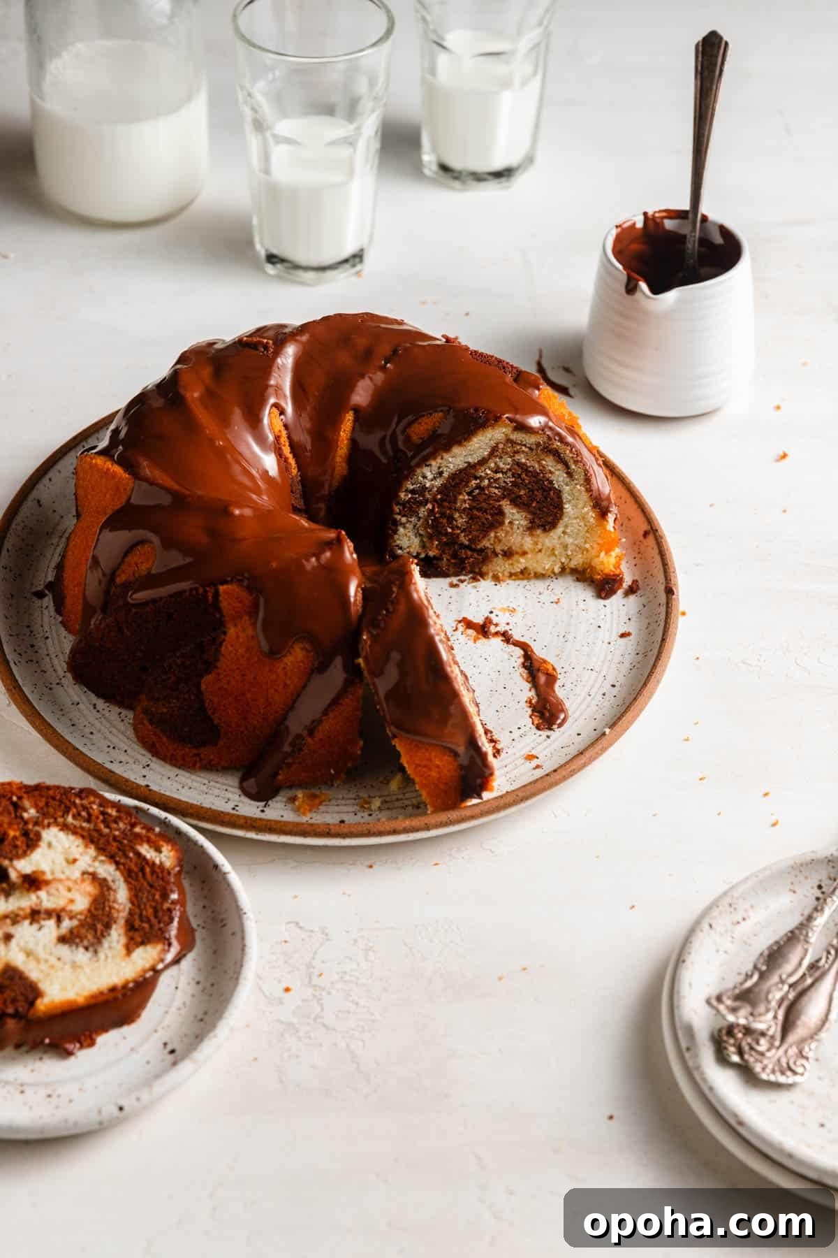 sliced bundt cake with cups of milk and chocolate glazed.
