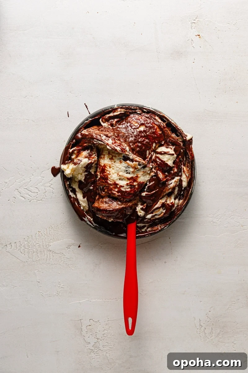 A bowl with dark and light batter and a spatula.