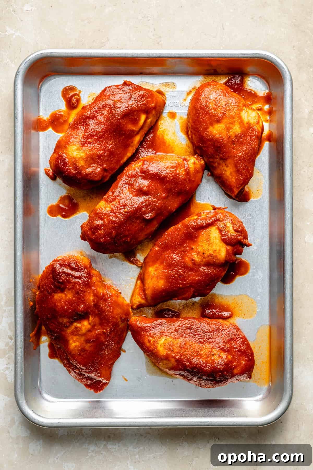 slow cooker cooker bbq chicken breasts on a sheet pan.