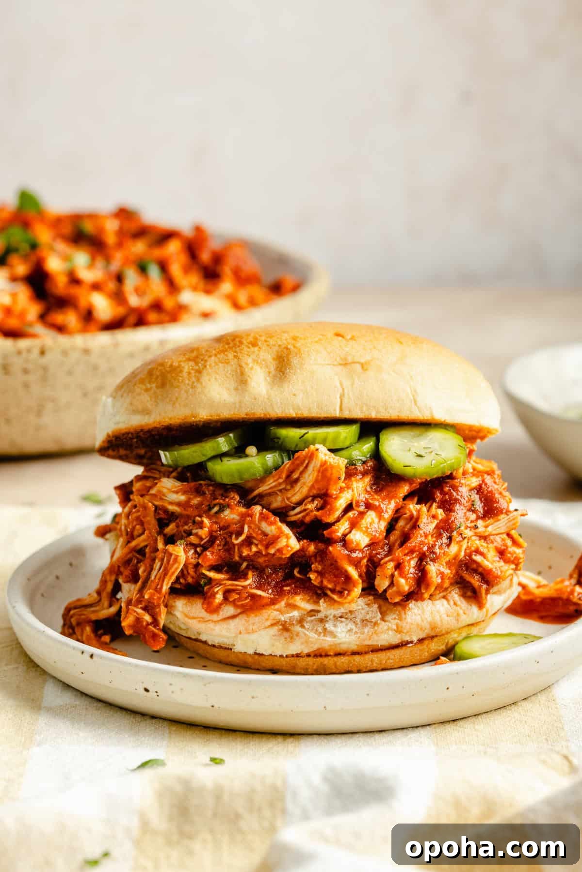 crock pot bbq chicken sandwich on a bun with pickles.