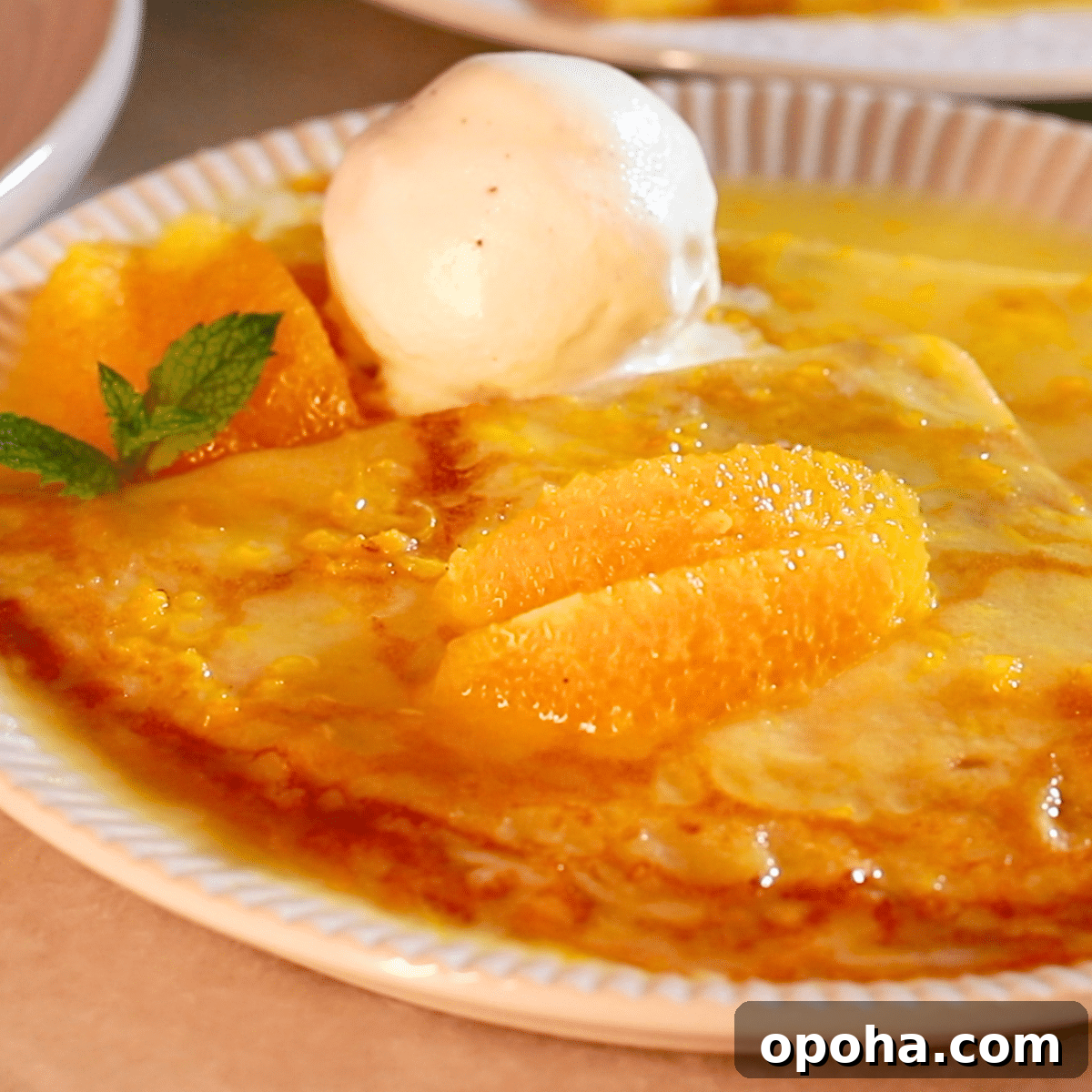 homemade crepes suzette on a plate with vanilla ice cream