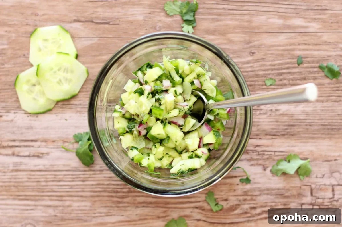 Pan-Seared Salmon with Refreshing Cucumber Salad 7 Glass bowl filled with fresh cucumber salsa ingredients.