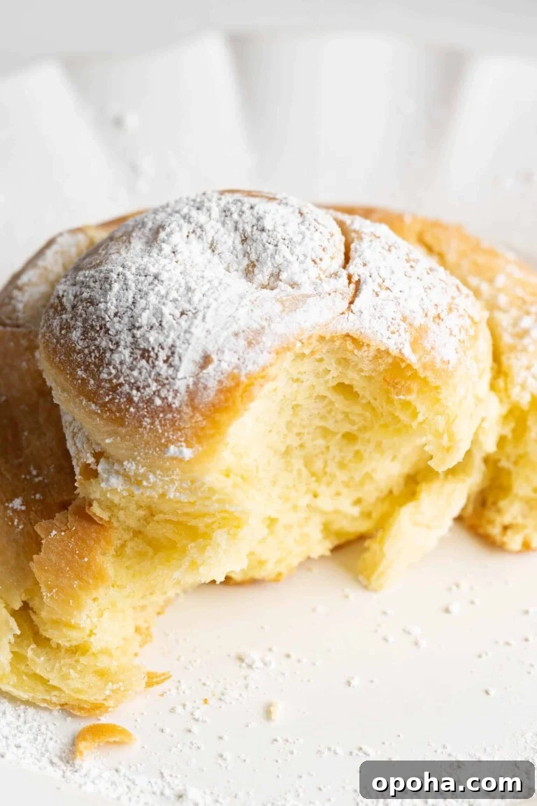 A sweet bun on a plate with a bite taken