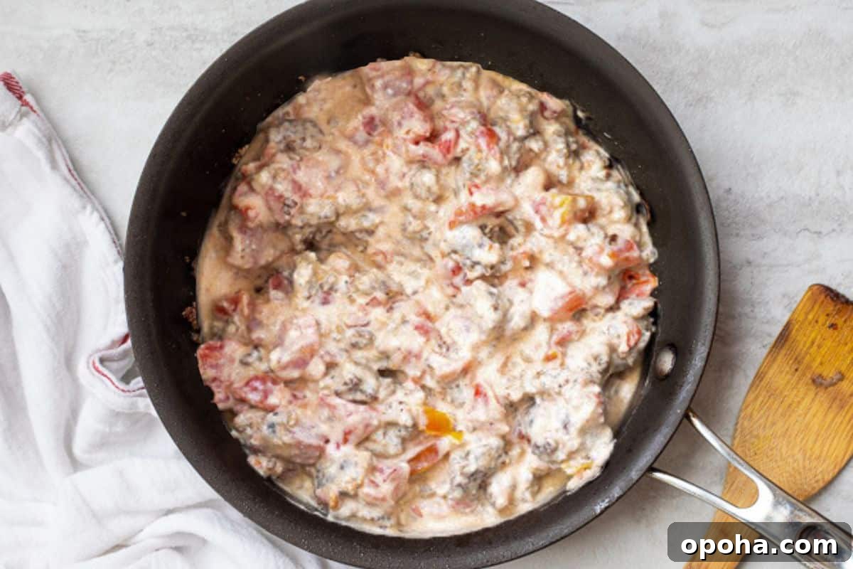Easy Sausage Cream Cheese Dip Cream cheese, rotel tomatoes and sausage in saute pan.
