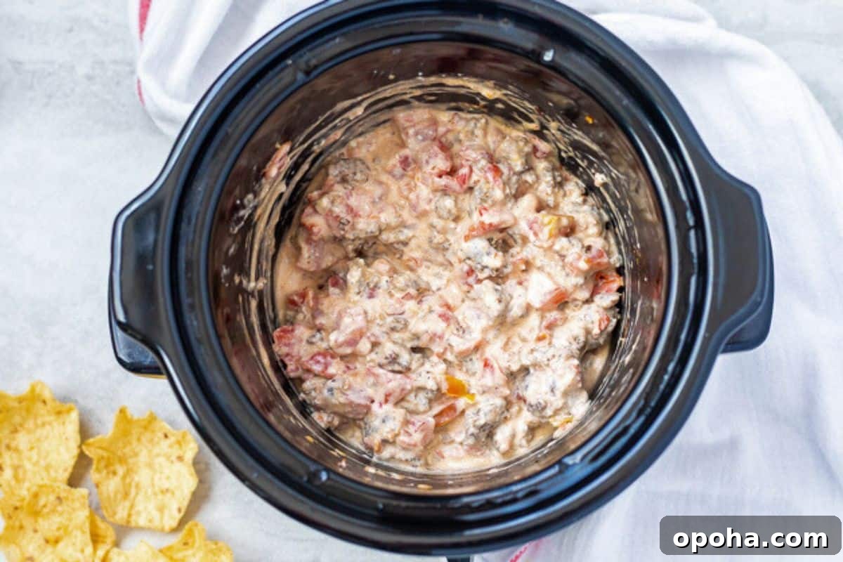 Easy Sausage Cream Cheese Dip Cheesy sausage dip in slow cooker after cream cheese has melted.