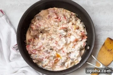 Spicy Rotel Sausage Dip Recipe for Game Day Snacks 4 Cream cheese, rotel tomatoes and sausage in saute pan.