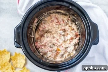Spicy Rotel Sausage Dip Recipe for Game Day Snacks 5 Cheesy sausage dip in slow cooker after cream cheese has melted.