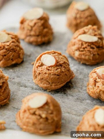 Almond butter protein bite on marble with almond slice.