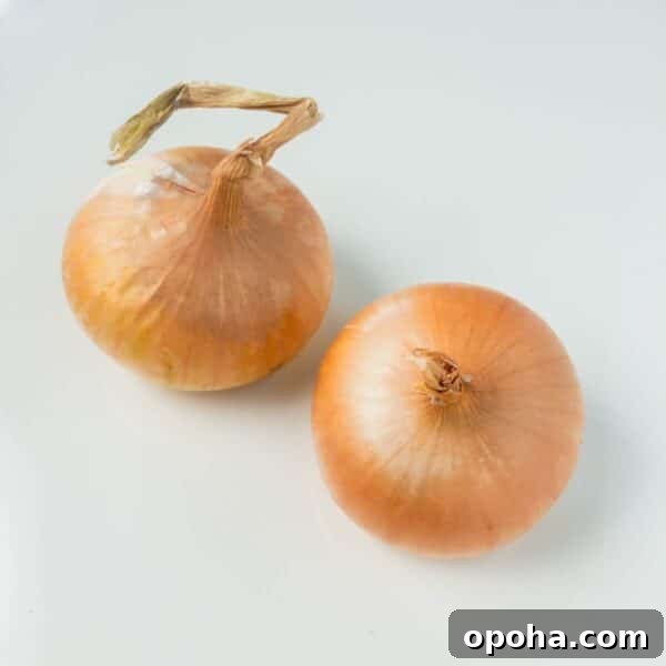 two yellow onions on white