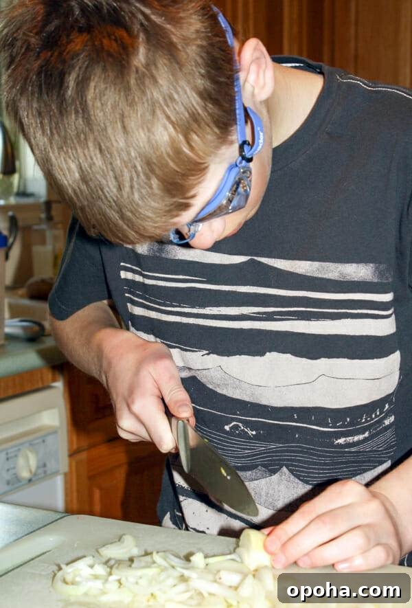 boy wearing goggles while cutting onions