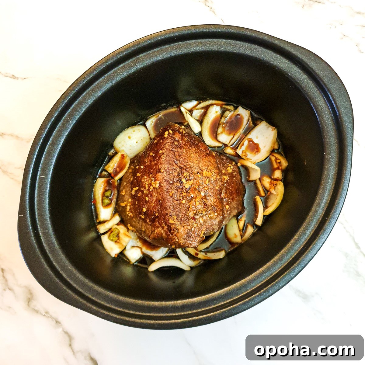 Slow-Cooker Mongolian Roast Beef Recipe for Tender, Savory Meat 7 Onions and a beef joint in a slow cooker, covered with stock.
