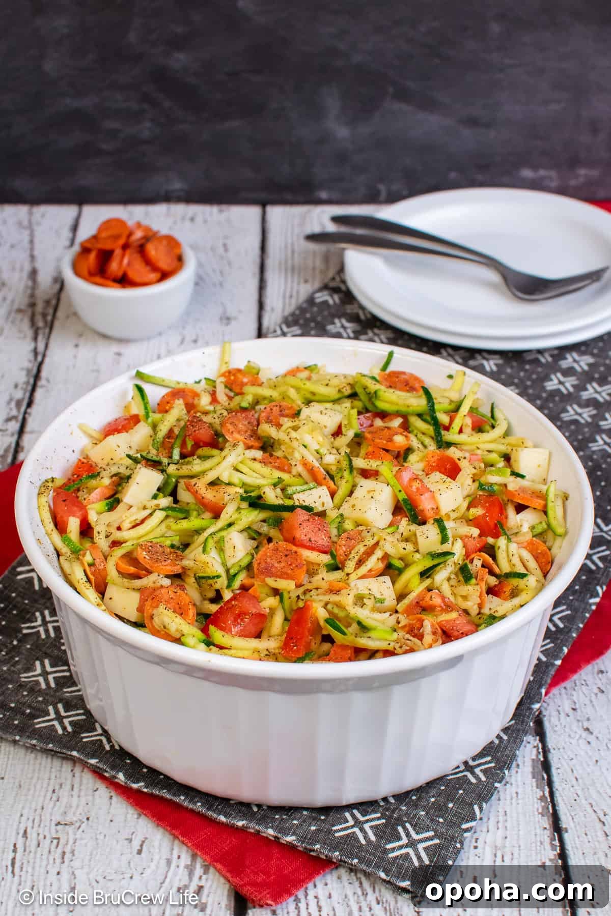 A white bowl filled with pizza zucchini salad.
