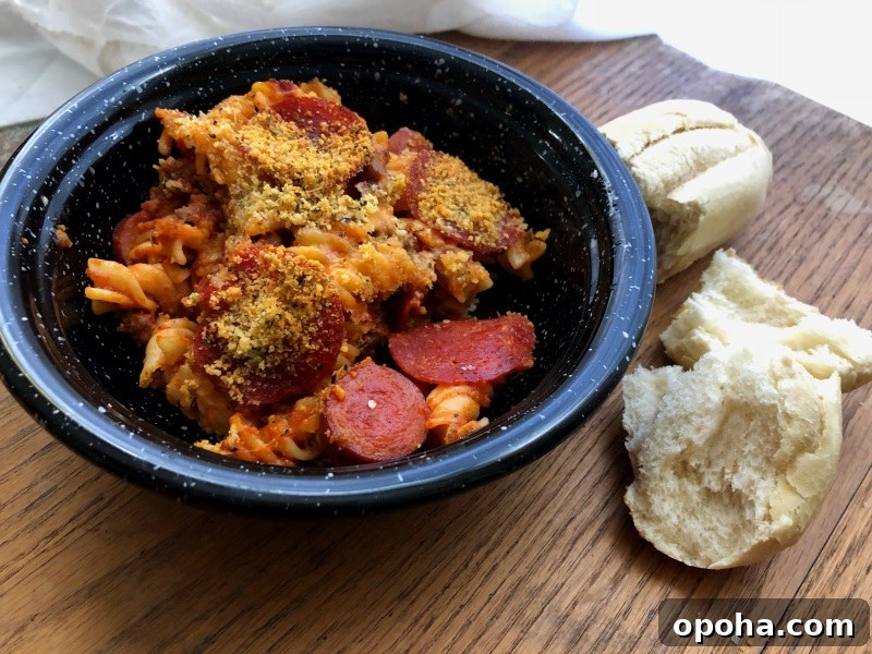 Black bowl of meat lovers pasta with bread on side