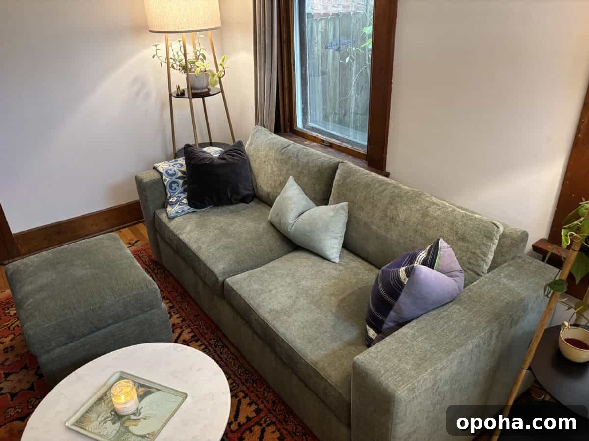 a side angle of a beautiful Rio Sofa from Medley with lamps on each side and a small circular table with scented candle in front of it