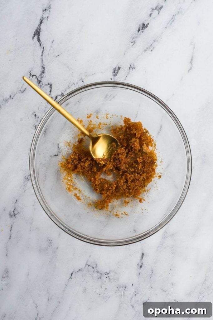 A clear bowl with spices mixed with olive oil for a turkey rub.