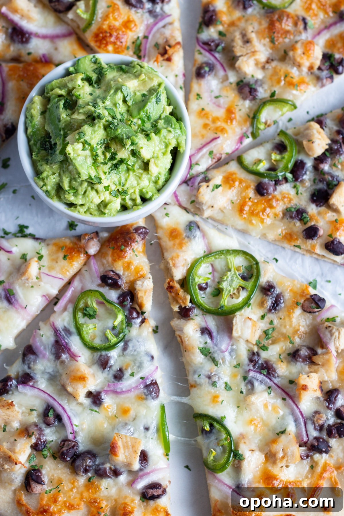 Chicken, Black Bean & Smashed Avocado Pizza Recipe 3 This is a close up picture of the pizza and little bowl of smashed avocado.