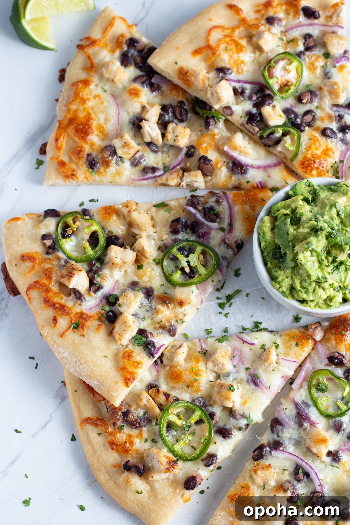 Chicken, Black Bean & Smashed Avocado Pizza Recipe 5 picture of pizza with chicken ,black beans, cheese, onion and jalapeño with a little bowl of smashed avocado.