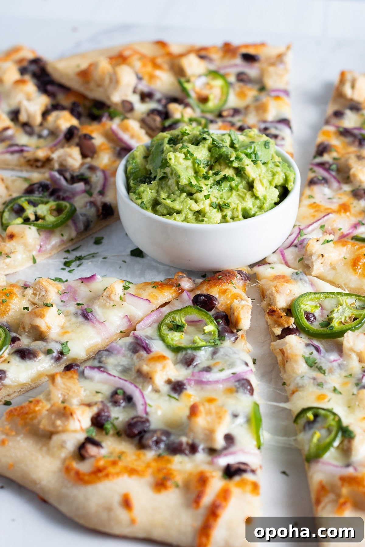 Chicken, Black Bean & Smashed Avocado Pizza Recipe 10 This is picture of pizza with chicken ,black beans, cheese, onion and jalapeño with a little bowl of smashed avocado.