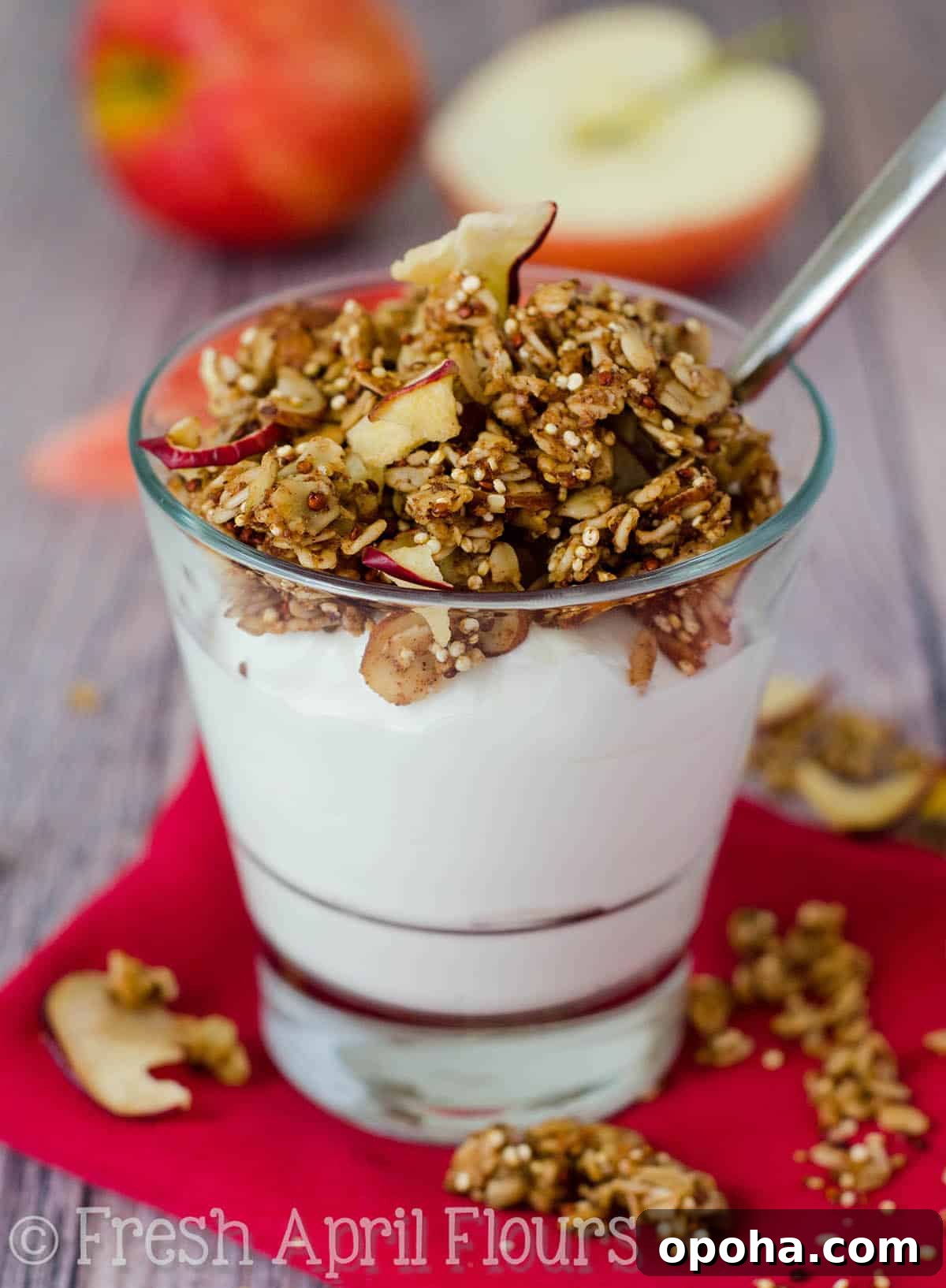 Apple Quinoa Granola Recipe: Crunchy Baked Apple Quinoa Clusters 5 Apple quinoa granola on top of a cup of yogurt with a spoon in it.