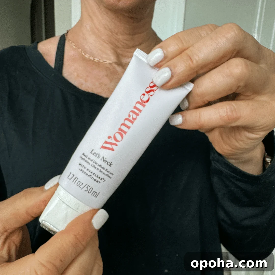 Top Anti-Aging Skincare Picks for Women Over 50 4 Woman holding up a white bottle of Womaness Let's Neck Serum holding onto the edges of the bottle.
