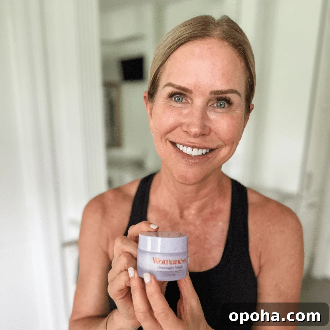 Top Anti-Aging Skincare Picks for Women Over 50 5 Chris Freytag wearing a black tank top holding up a container of the Womaness Overnight Magic Serum.