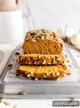 pumpkin bread cut showing inside; with two slices in front of loaf
