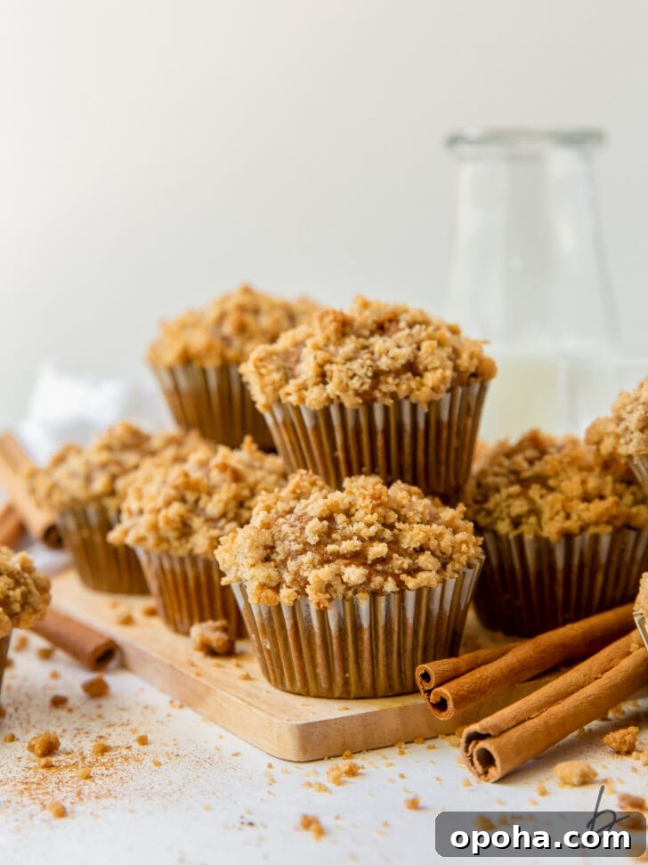 Moist Pumpkin Muffins Recipe for Fall Baking 7 pumpkin muffins with streusel in pile on small wood cutting board next to cinnamon sticks