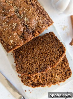 two slices of pumpkin gingerbread next to the loaf of bread.
