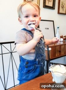 Baby-Led Weaning Meal Ideas: What Theo Loves to Eat 2 This is a photo of my son eating yogurt at the table. He is making a mess and has yogurt all over his face. This is for an article called 'What Theo Eats'.