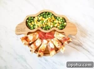 Baby-Led Weaning Meal Ideas: What Theo Loves to Eat 4 Naan pizza sticks with peas and corn on a bamboo sheep plate.
