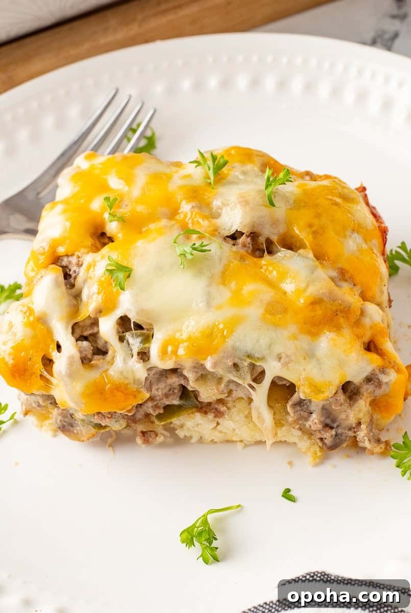 Philly Cheesesteak Casserole with Ground Beef — Savory Comfort Bake 2 Philly cheesesteak casserole on a white plate with fork.