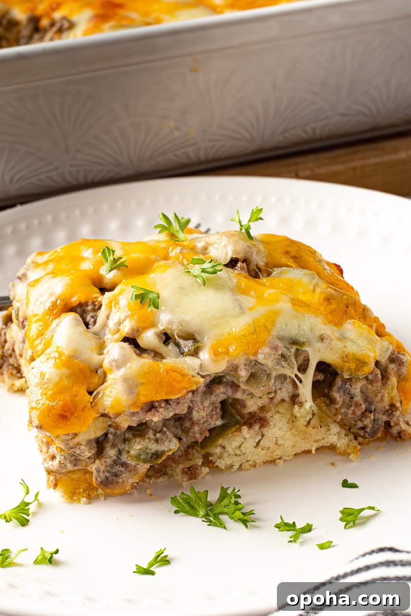 Philly Cheesesteak Casserole with Ground Beef — Savory Comfort Bake 13 Slice, or helping of Philly casserole on a plate with fresh parsley.