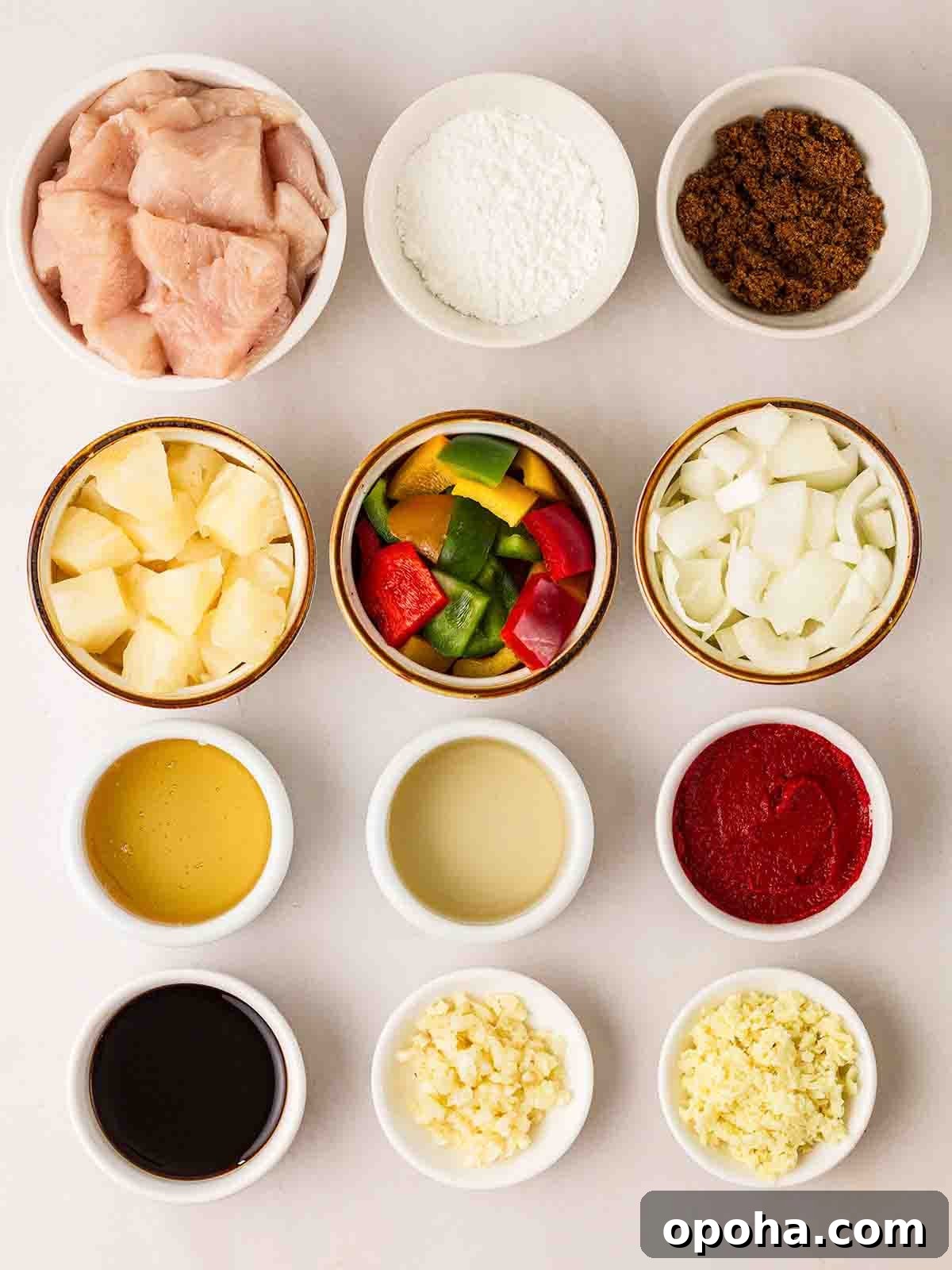 Sweet and Sour Chicken Recipe — Quick Home-Style Version 3 Small bowls of ingredients to make Sweet and Sour Chicken laid out on a white counter.