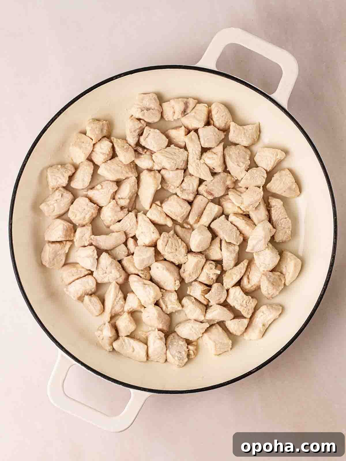 Sweet and Sour Chicken Recipe — Quick Home-Style Version 4 A white pan filled with cooked pieces of cubed chicken breast, for step 1 in the recipe for Sweet and Sour Chicken.