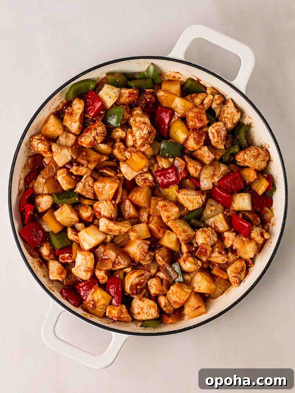 Sweet and Sour Chicken Recipe — Quick Home-Style Version 5 Chicken with peppers, pineapple in a pan for step 2 in Sweet and Sour Chicken.