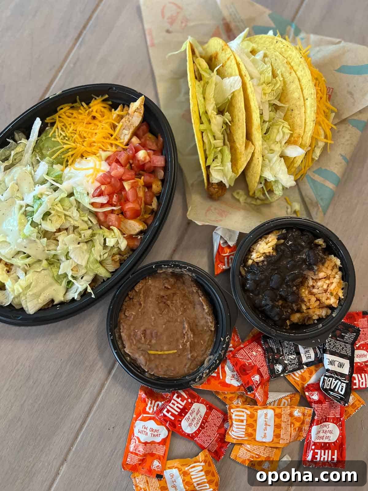 overhead shot of tacos, beans and taco bowl with hot sauce from taco bell
