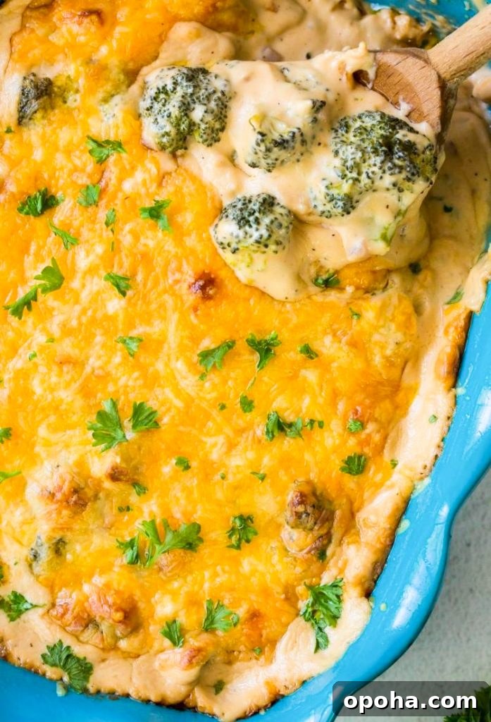Low-Carb Broccoli and Cheese Casserole Recipe 2 keto broccoli and cheese casserole in a blue baking dish with a wooden spoon, green napkin and parsley