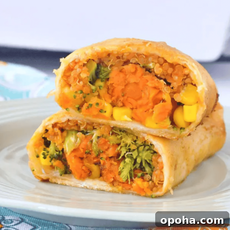 one crispy sweet potato veggie enchilada sliced in half and stacked on a light green plate, white ceramic baking dish of enchiladas in background