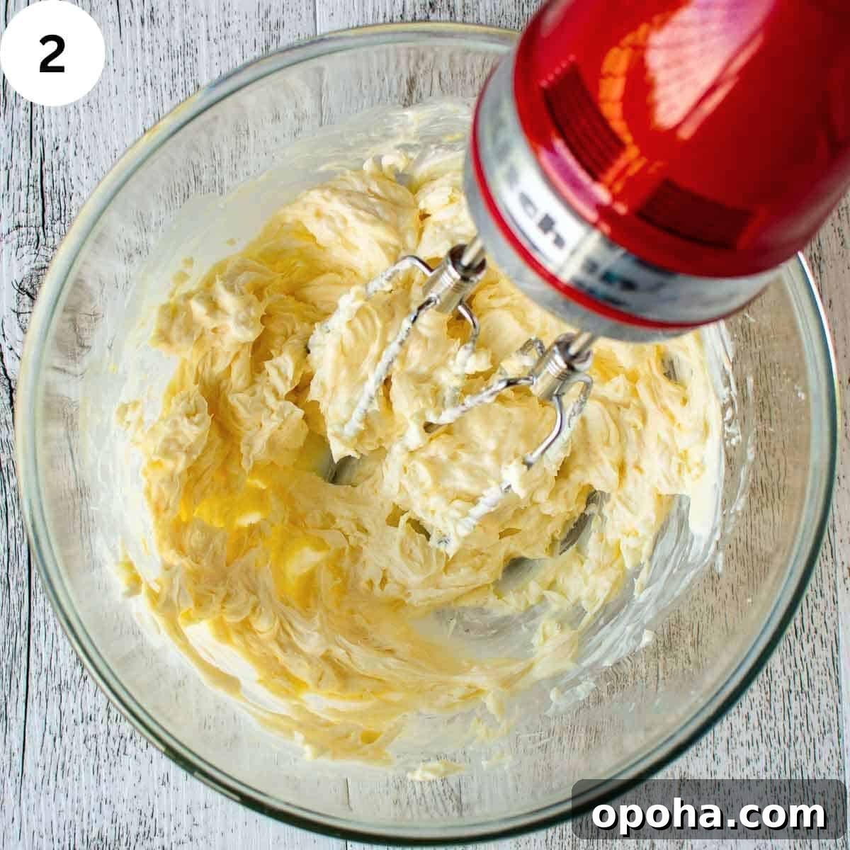 Raspberry Danish Recipe: Flaky Pastry with Fresh Raspberry Filling 5 Beating creamy mixture in a glass bowl with electric beaters.