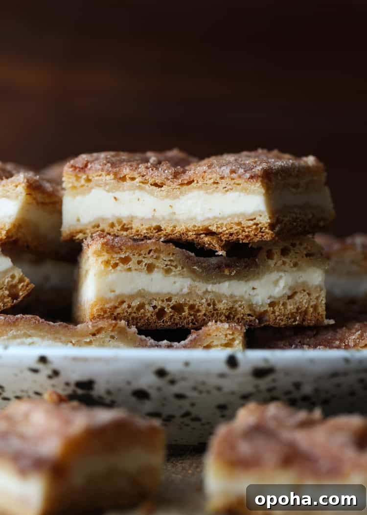 Sopapilla Cheesecake Bars Two sopapilla cheesecake bars stacked on a plate.