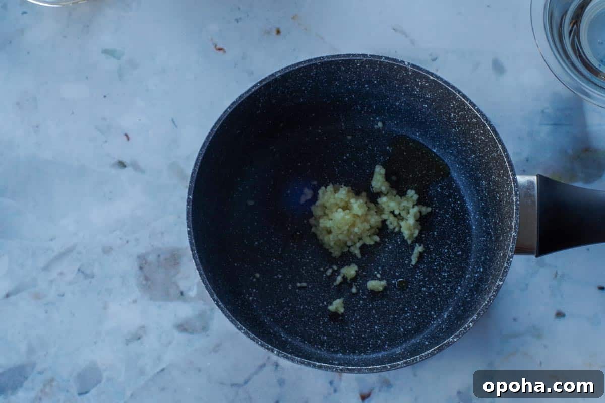 garlic and oil sauteing in a small dark pot