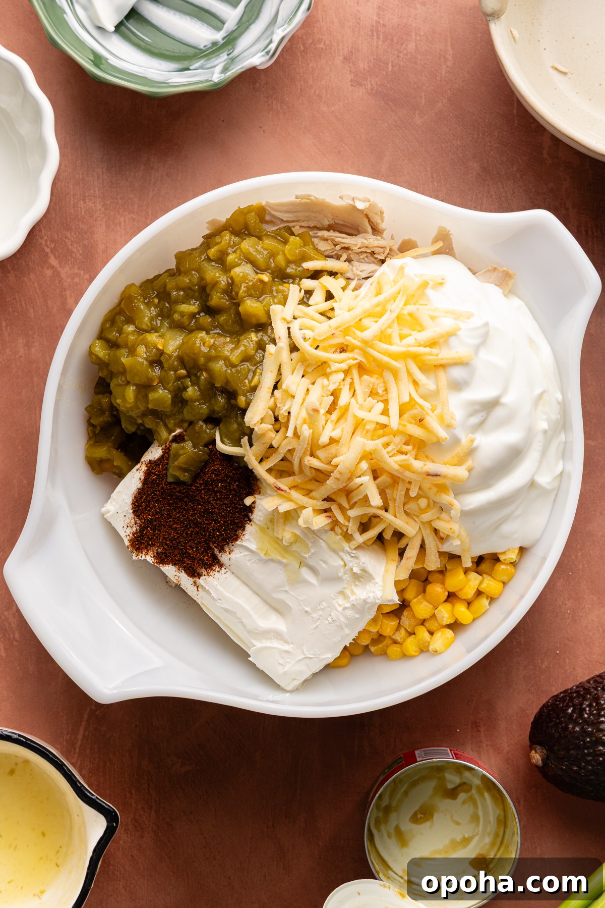 A large mixing bowl filled with ingredients to make a chicken enchilada dip