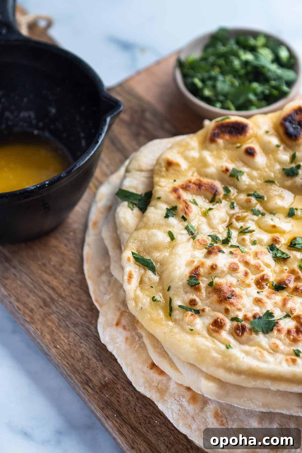Sourdough Discard Naan Recipe: Crispy, Chewy Flatbread 9 Stack of sourdough naan with butter melter and fresh cilantro.