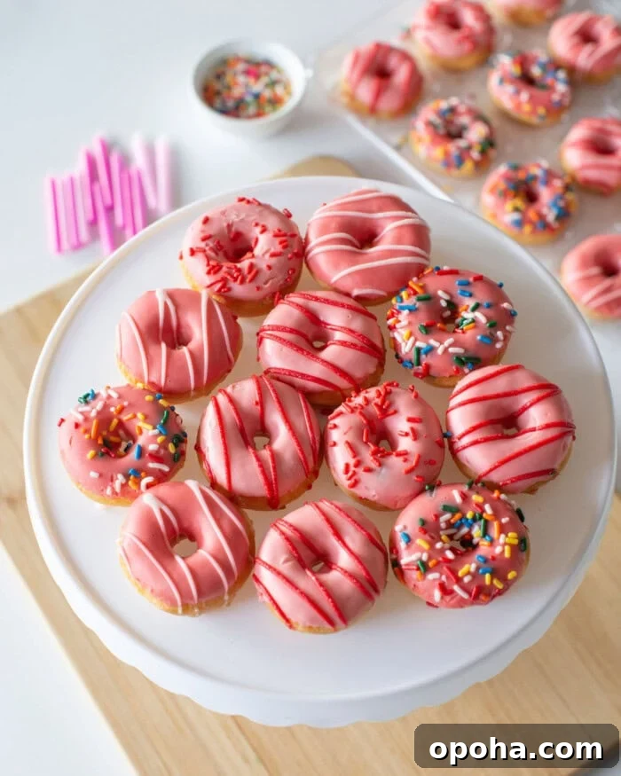 Donut Cake Tower Ideas: Show-Stopping Dessert Centerpieces 6 A plate of mini donuts coated in pink icing is arranged on a cake stand.