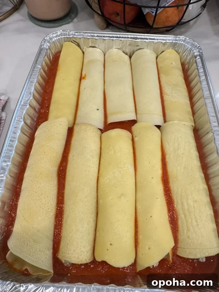 Crepe-Style Manicotti Recipe: Light Italian Stuffed Crepes 2 Crepe Style Manicotti in the pan with sauce before baking