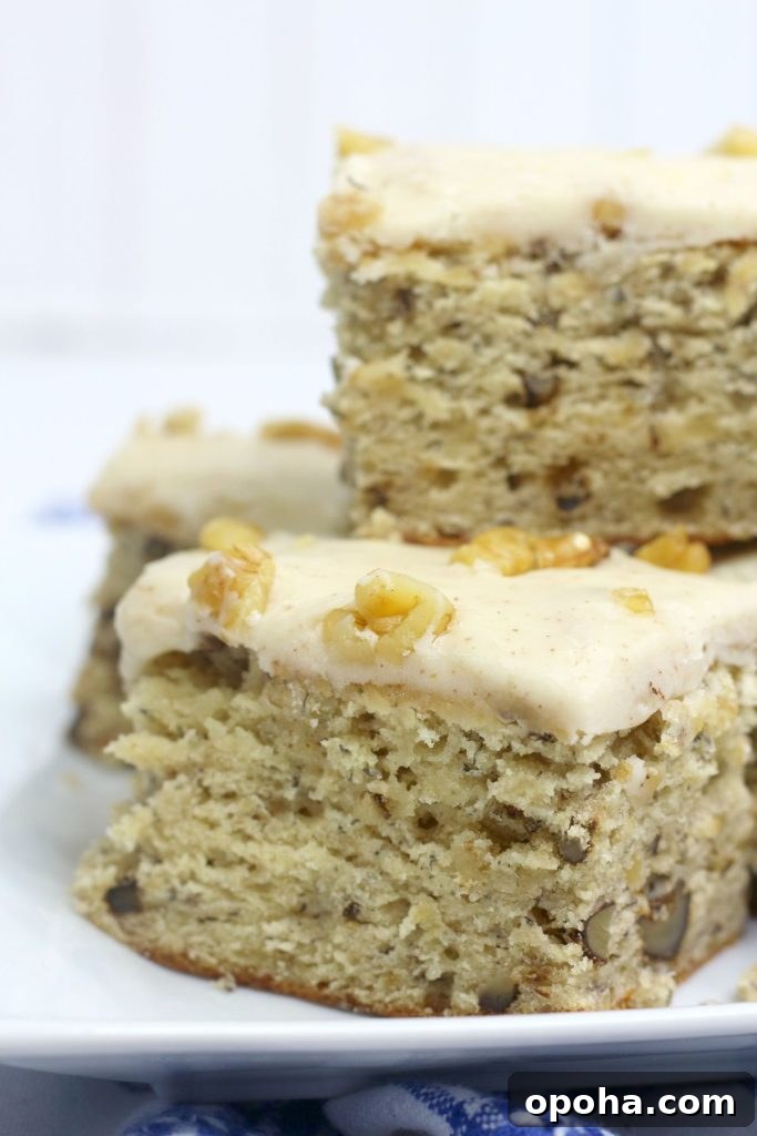 four banana walnut brownies stacked on a square plate.