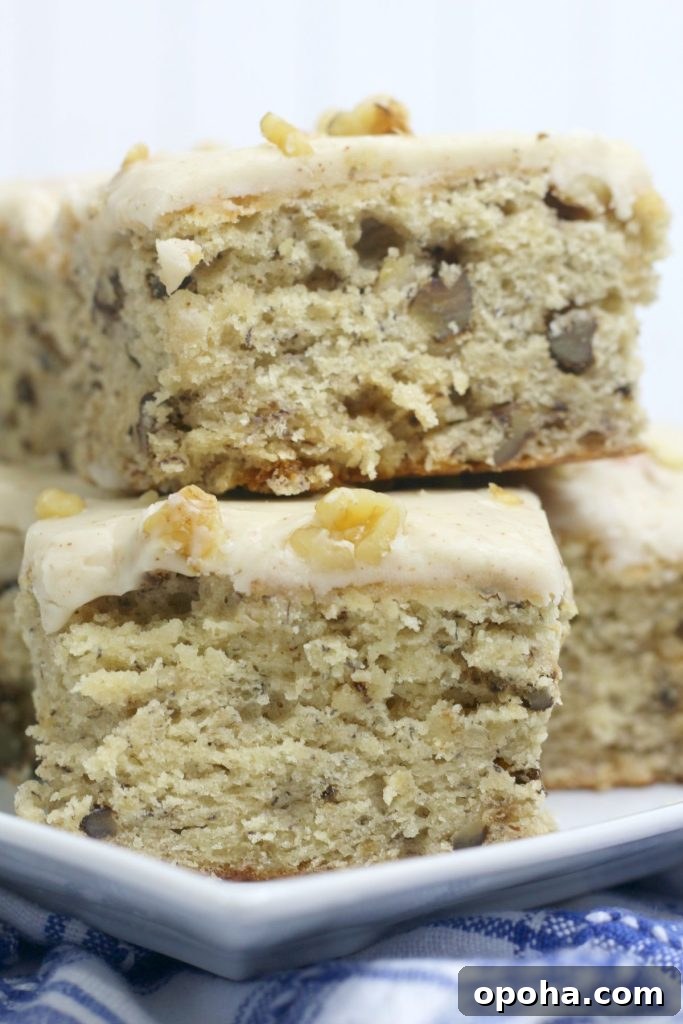 four banana walnut brownies stacked on a square plate.