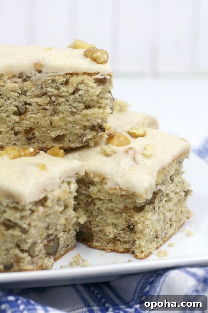 four banana walnut brownies stacked on a square plate.