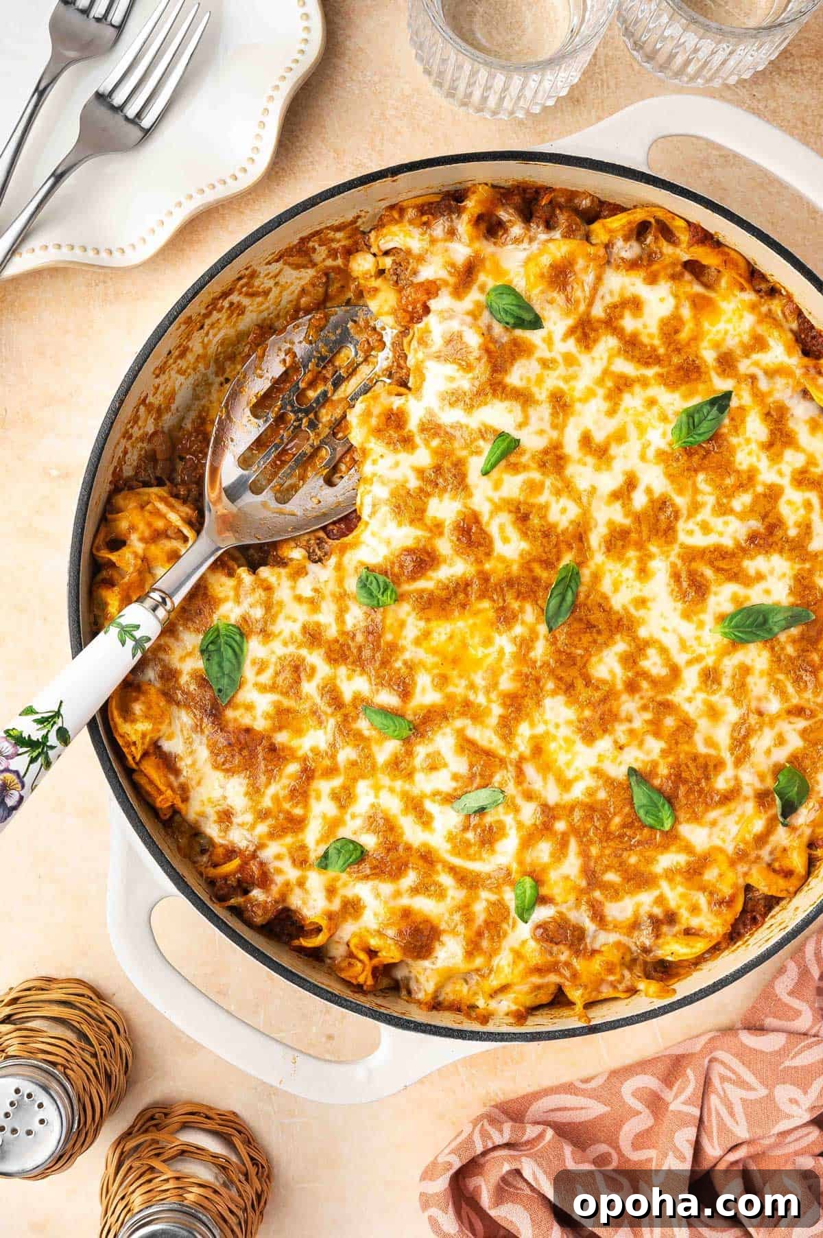 Tortellini Lasagna Bake: Cheesy Italian Pasta Casserole Recipe 2 A serving spoon inside of a shallow dutch oven of tortellini lasagna.
